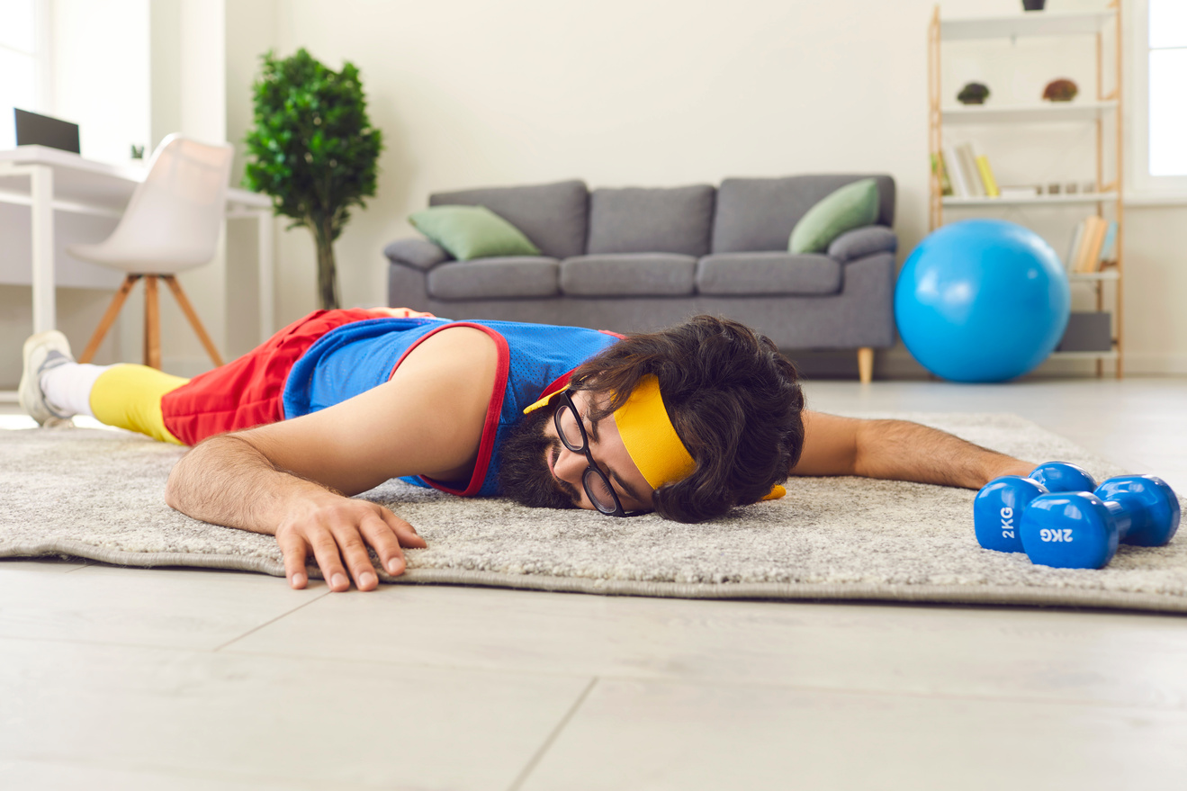 Tired Unmotivated Young Sportsman Lying on Floor after Giving up Fitness Training with Dumbbells
